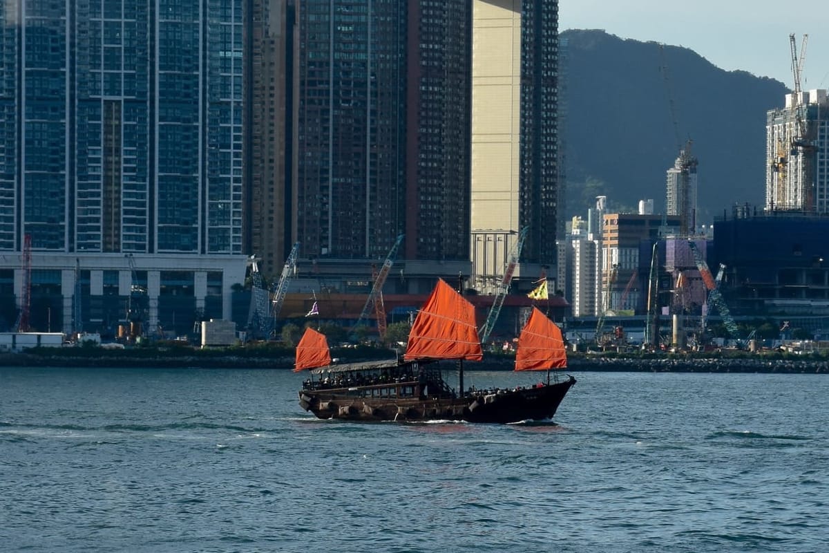 A red junk boat sailing in the sea on a sunny afternoon