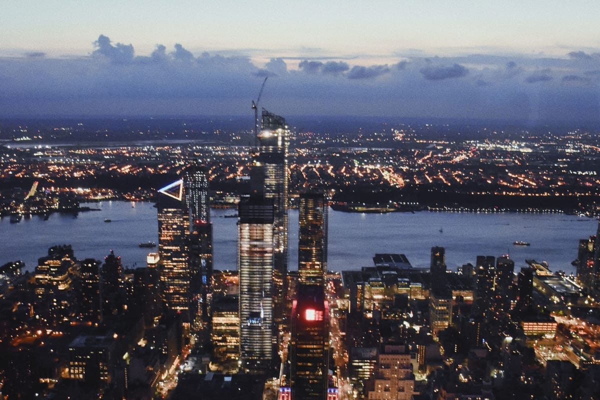 New York City viewed from Empire Building at dusk, featuring skyscrapers with glowing lights